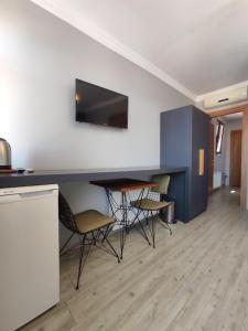 a room with a table with chairs and a tv on a wall at Ore Pera Suites in Istanbul