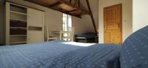 een slaapkamer met een blauw bed en een houten deur bij FairSchlafen-Dachstudio in Bücken