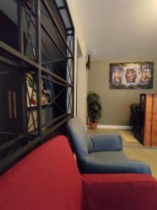 ein Wohnzimmer mit einer Couch und einem roten Sessel in der Unterkunft Ore Pera Suites in Istanbul