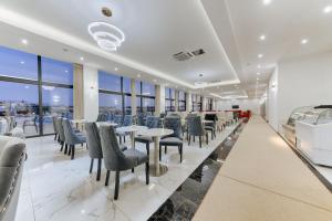 un comedor con mesas, sillas y ventanas en Hotel BH, en Dobra Voda