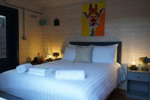 Un dormitorio con una cama blanca con toallas. en West Wicklow Glamping with Hot Tub, en Baltinglass
