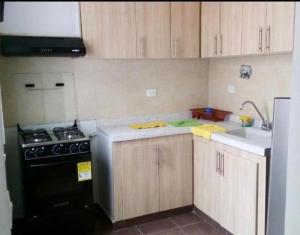 a kitchen with wooden cabinets and a black stove at Girardot - Via Ricaurte Casa de dos pisos - Colombia in Girardot