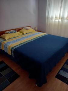 um quarto com uma cama grande e um cobertor azul em Tedi em Rijeka
