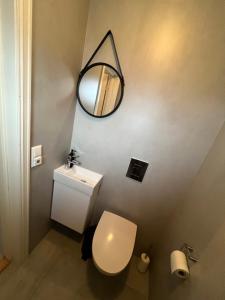 a bathroom with a white toilet and a mirror at Et koselig hus i vakre Lofoten in Stamsund