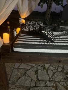 uma cama com duas almofadas e duas velas em Mama’s Sunshine Garden Villa em Áyios Ilías