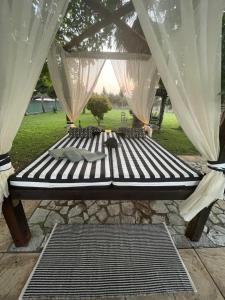 a black bed with curtains and pillows on it at Mama’s Sunshine Garden Villa in Áyios Ilías