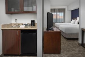 Habitación de hotel con cocina y dormitorio con cama en SpringHill Suites by Marriott Portland Vancouver, en Vancouver