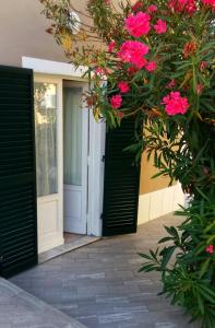 une porte d'entrée d'une maison avec des fleurs roses dans l'établissement The Clarinet, à Monsummano