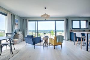 a living room with a blue couch and chairs at L'Élégante Confort, Clim & Vue Imprenable in Bassillac