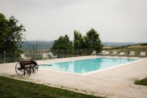 a swimming pool with chairs and a bench next to it at Country Relais La Torretta Baronale in San Giorgio Montagna