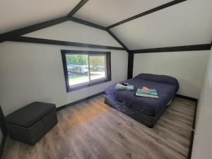 Habitación pequeña con cama y ventana en Noah's Ark Campground, en Revelstoke