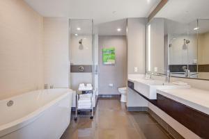 a bathroom with two sinks and a tub and a toilet at Vdara Hotel & Spa in Las Vegas