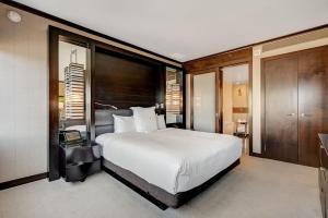 a bedroom with a large white bed and wooden walls at Vdara Hotel & Spa in Las Vegas