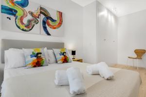 une chambre blanche avec un lit blanc avec deux serviettes dans l'établissement Terralmar Beach & City, à Malaga 16 autres photos