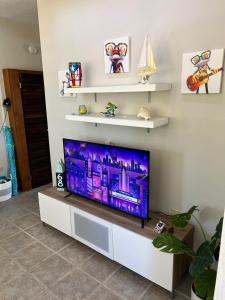 Una televisión o centro de entretenimiento en 2-BR Modern Oceanfront Apt Steps from Playa Sucia