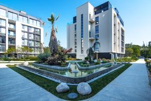 a courtyard with a fountain in front of two buildings at Azur Deluxe Flats in St. St. Constantine and Helena