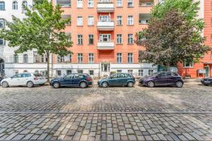 un grupo de autos estacionados en un estacionamiento frente a un edificio en 2 Zimmer Apartment,4 Betten am Sbahnhof Köpenick,vollmöbliert en Berlín