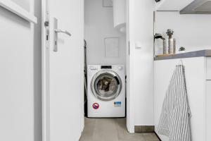 a white laundry room with a washer and dryer at 2 Zimmer Apartment,4 Betten am Sbahnhof Köpenick,vollmöbliert in Berlin