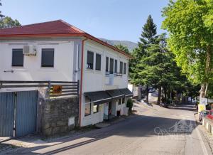 a white building on a street with a fence at Casa da Floresta in Covilhã