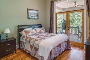 a bedroom with a bed and a sliding glass door at Waterfront Loranger Cottage Hot Tub, Deck and Grill in Loranger