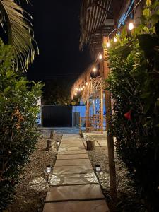 um caminho que leva a um edifício à noite com luzes em COLIBRI GUEST HOUSE em Puerto López