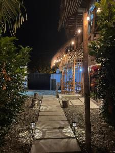 a pathway leading to a building at night at COLIBRI GUEST HOUSE in Puerto López