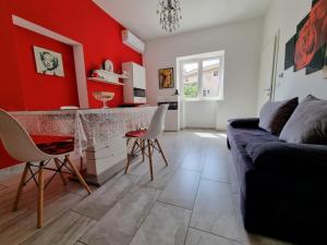 sala de estar con sofá y pared roja en Glorianita sweethome,centro, FREE parking,SELF CHECK- IN, en Šibenik
