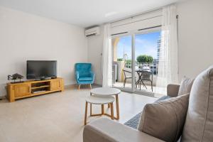 a living room with a couch and a tv at Apartamento WELCS EMP 093 con vistas al Canal in Empuriabrava