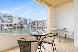 a balcony with a table and chairs and a view of a harbor at Apartamento WELCS EMP 093 con vistas al Canal in Empuriabrava