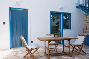 a wooden table and chairs on a patio at Villa Azzurra a pochi passi dal mare in San Vito lo Capo