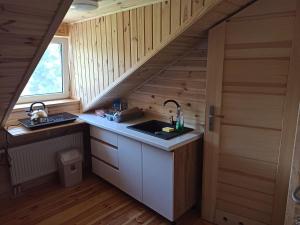 a kitchen with a sink and a staircase in a tiny house at Kwatera u Stasia in Szczebrzeszyn