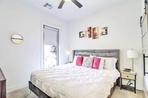 1 dormitorio blanco con 1 cama grande con almohadas rosas en Private Rooftop Terrance-Walk Score 81-Shopping District-King Bed-Parking 4003, en Scottsdale