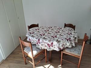 a dining room table with a flowered table cloth on it at Yulia Apartman in Pula