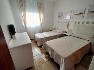 a hotel room with two beds and a window at Casa Atlantica Golf & Sea view in Caleta De Fuste