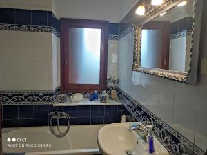 a bathroom with a sink and a tub and a mirror at MESONISI maisonette in Afissos +59 photos