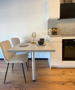 a table and chairs in a kitchen with a stove at BaMo Studio - city living downtown in Klagenfurt