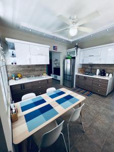 卡沃羅霍的住宿－2-BR Modern Oceanfront Apt Steps from Playa Sucia，厨房配有桌椅和冰箱。