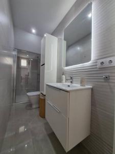 a white bathroom with a sink and a toilet at Nueva Almería beach & chill in Almería +20 photos