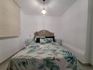 a bedroom with a bed with a palm tree comforter at Nueva Almería beach & chill in Almería