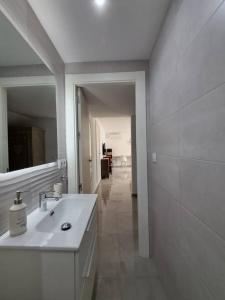 a white bathroom with a sink and a mirror at Nueva Almería beach & chill in Almería
