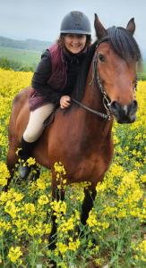 uma mulher montada num cavalo num campo de flores em Pod Aniołem em Świerzawa