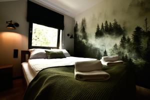 um quarto com uma cama com toalhas em Za Górami em Wetlina