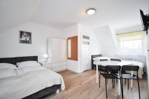 a bedroom with a bed and a table and chairs at U KAZI in Niechorze