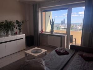 salon z kanapą i dużym oknem w obiekcie Apartament z widokiem na morze w mieście Gdynia