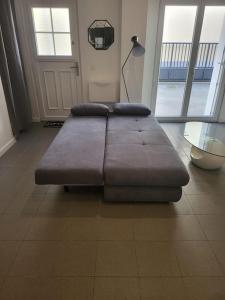 un sofá grande sentado en el suelo en una habitación en Appartement spacieux 44m2, paisible et proche gare Vernon Giverny, en Vernon
