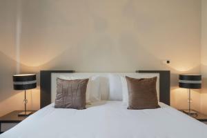 a bedroom with a large white bed with two lamps at Vila Formosa II by An Island Apart in Funchal +26 photos