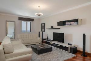 a living room with a couch and a tv at Vila Formosa II by An Island Apart in Funchal