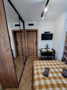 Zimmer mit einem Bett, einem Tisch und einem TV in der Unterkunft 3miasto Gdynia Apartamenty in Gdynia