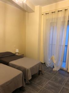um quarto com 2 camas e uma janela em Casa Renzo em LʼAquila