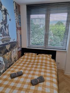 Bett in einem Zimmer mit zwei Paar Hausschuhen in der Unterkunft 3miasto Gdynia Apartamenty in Gdynia
